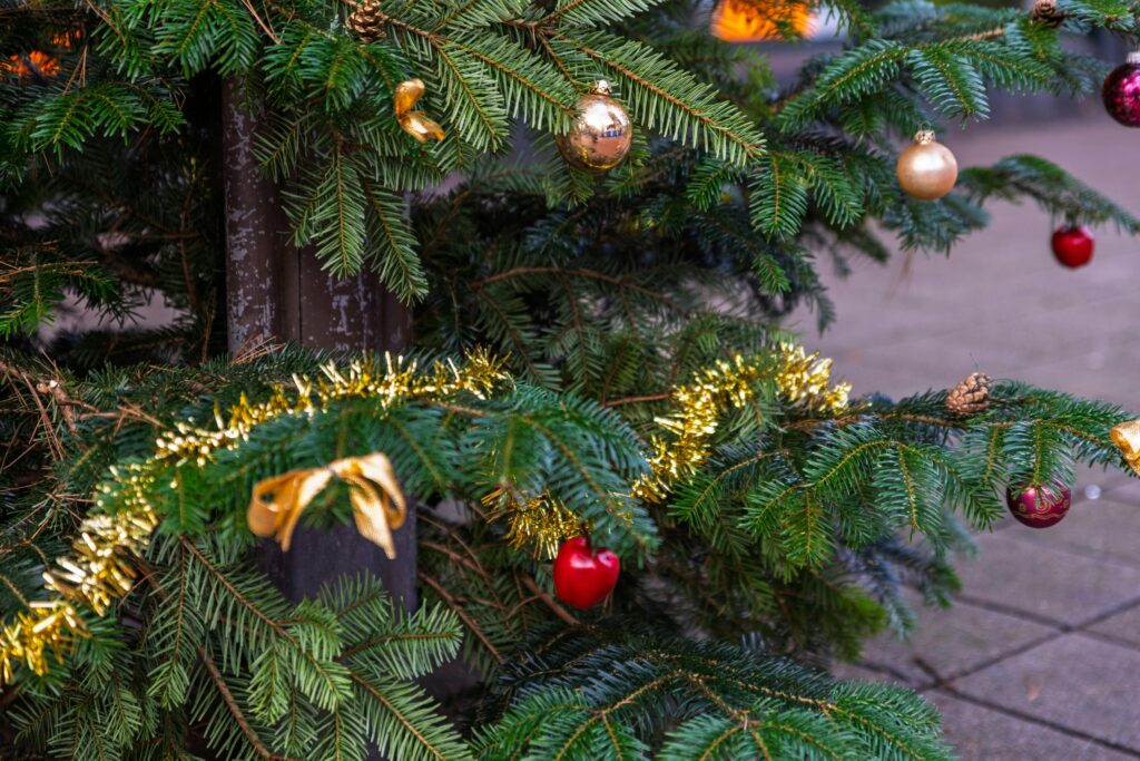 Close-up of a decorated Christmas tree with baubles and tinsel, embracing the festive spirit.