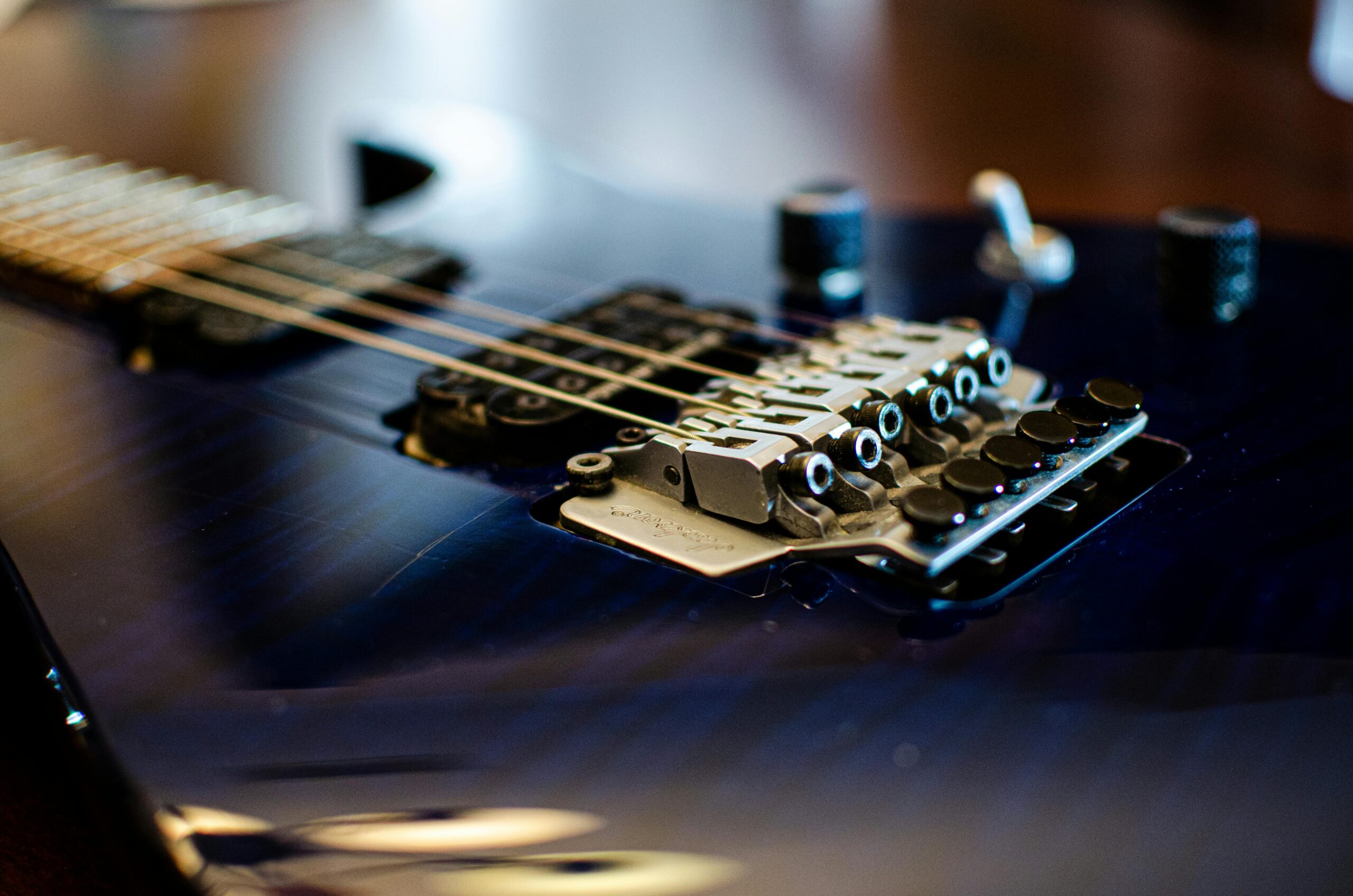 Detailed close-up of an electric guitar's bridge showcasing strings and tuning pegs.